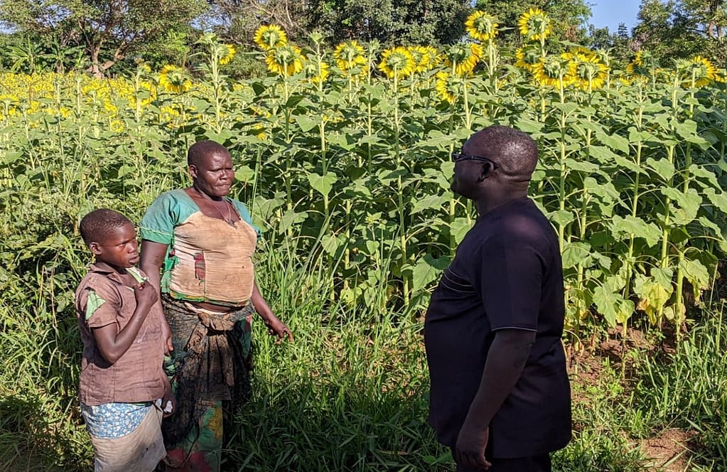 Engineer Andrew (Civil Engineer MoLG) Olal interacting with a farmer in her farm in Agago District.