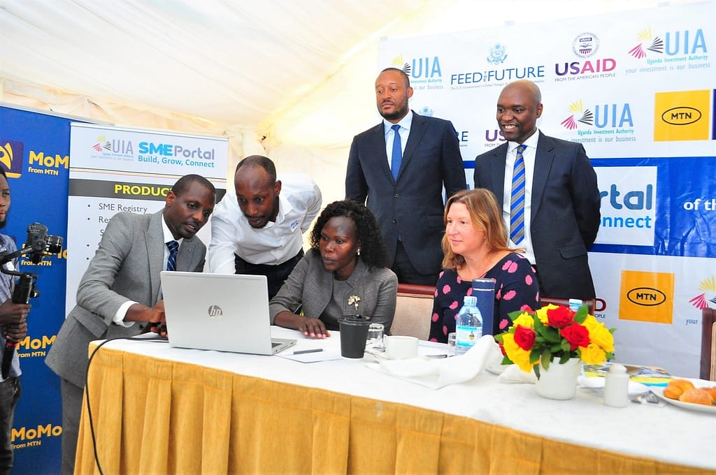 State Minister of Finance Evelyn Anite,  at a ceremony in Kampala, flanked by USAID’s Director of Economic Growth Office, Amy Beeler.