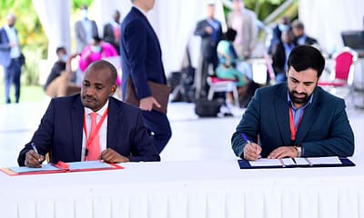 Frank Tumwebaze and an Iranian delegate jot down notes